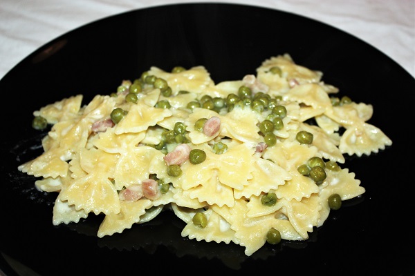 Farfalle con feta e piselli servite